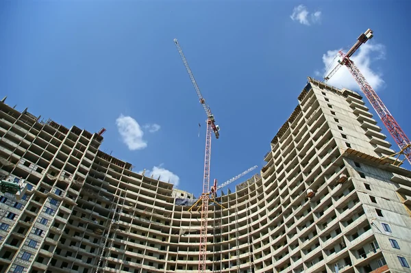 Guindaste de construção no fundo de um edifício de vários andares — Fotografia de Stock