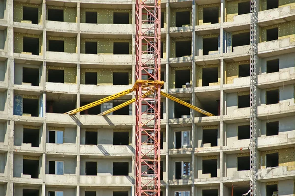 Grúa de construcción en el fondo de un edificio de varios pisos — Foto de Stock