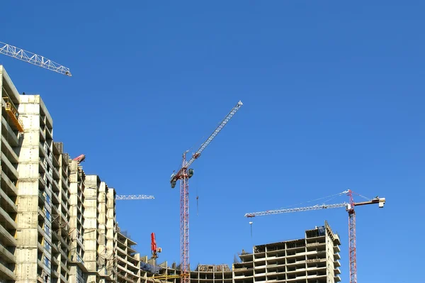 Grúa de construcción en el fondo de un edificio de varios pisos — Foto de Stock
