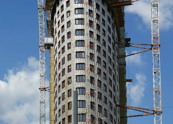 Byggnaden kranen på bakgrund av en flera våningar byggnad — Stockfoto
