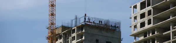 Baukran im Hintergrund des im Bau befindlichen Gebäudes — Stockfoto
