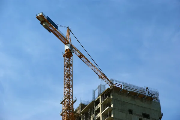 Gru da costruzione sullo sfondo dell'edificio in costruzione — Foto Stock