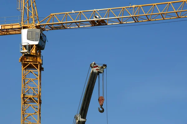 Modern konstruktion kranar på blå himmel bakgrund — Stockfoto