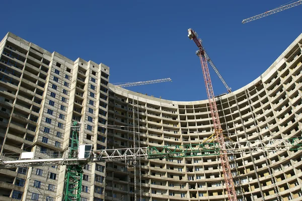 Grúa de construcción en el fondo del edificio en construcción — Foto de Stock