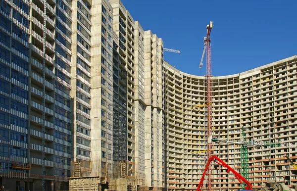 Building crane at the background of building under construction — Stock Photo, Image