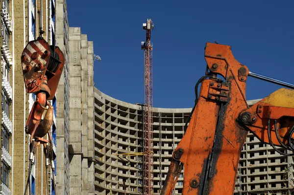Строительный кран на фоне строящегося здания — стоковое фото