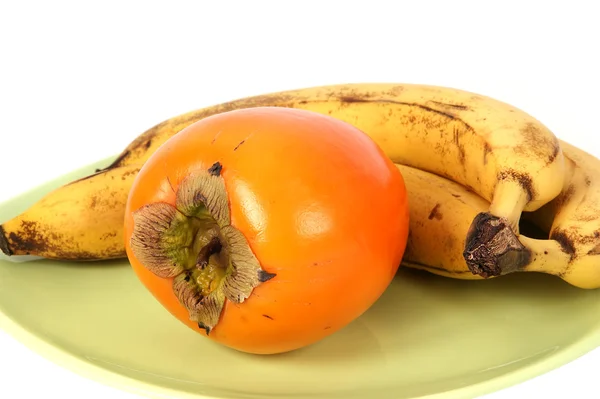 stock image A bunch of bananas and persimmons