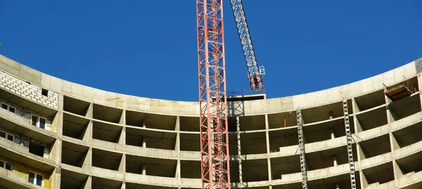 Grúa de construcción en el fondo del edificio en construcción — Foto de Stock