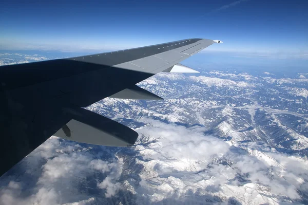 View of airplane wing, clouds and the Earth from the airplane — Stock Photo, Image