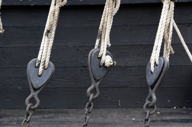 Pulley block on an old wooden sail boat with ropes clipart