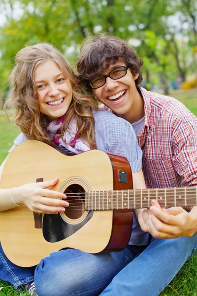 Teens having fun with guitar in park — Stock Photo, Image