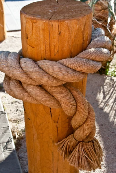 Corda pesada amarrada no poste de madeira — Fotografia de Stock