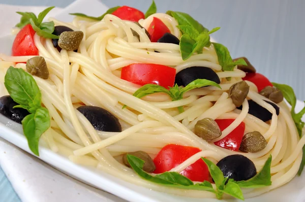 Espaguete com tomate, alcaparras e manjericão com azeitonas — Fotografia de Stock