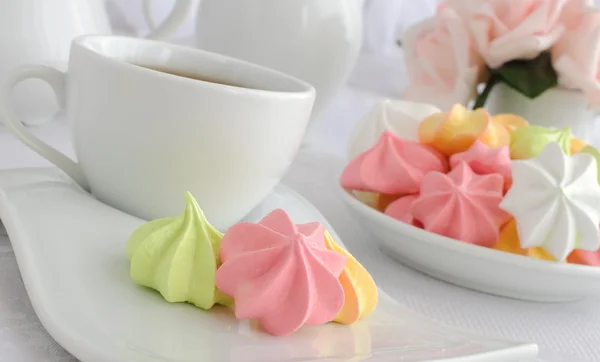 Galletas de merengue en un plato con una taza de café — Foto de Stock