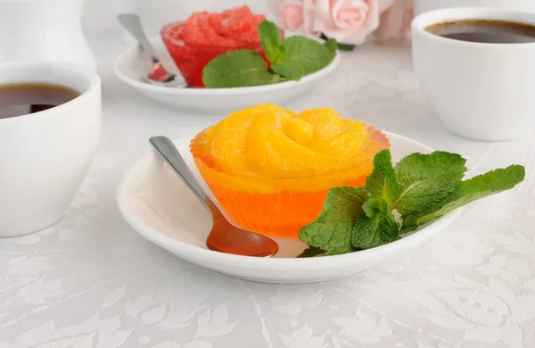 Una tazza di caffè e gelatina d'arancia con fette di arancia fresca — Foto Stock