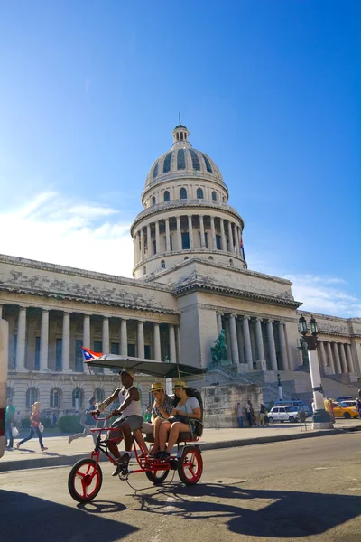 Um carro-bicicleta com os turistas circulam em frente ao Capitólio — Fotografia de Stock