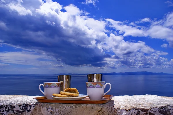 Греческий кофе на стене и синее море — стоковое фото