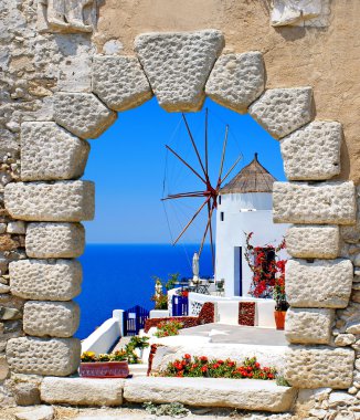 Windmill through an old window in Santorini island clipart