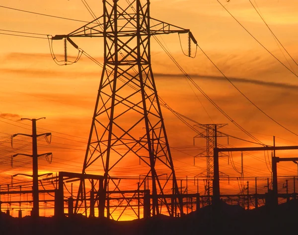 Pylons de eletricidade ao pôr-do-sol laranja Fotos De Bancos De Imagens