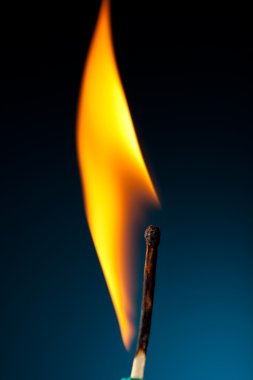 Burning match with tongue of flame on blue clipart