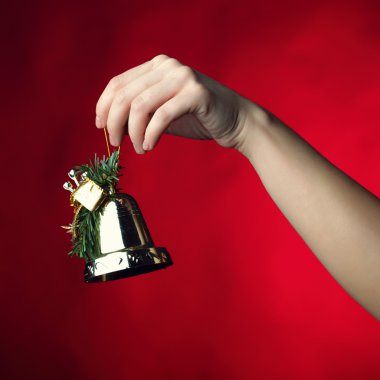 Hand holding a Christmas bell clipart