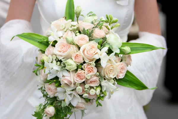 Uma imagem de uma noiva segurando seu buquê de rosas — Fotografia de Stock