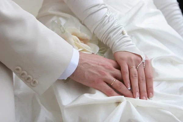 Руки жениха и невесты с золотыми кольцами — стоковое фото