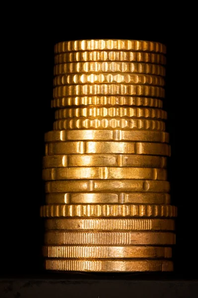 Column of golden money isolated on black — Stock Photo, Image