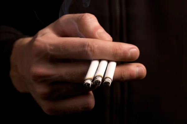 Fumador sosteniendo tres cigarrillos —  Fotos de Stock