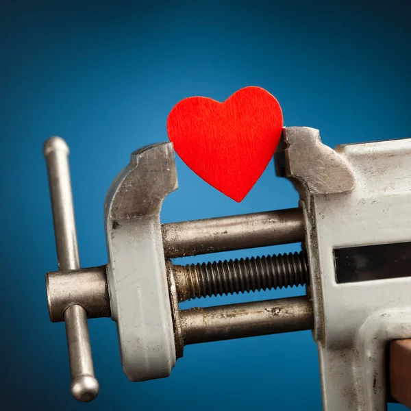 Red heart in the vice tool — Stock Photo, Image