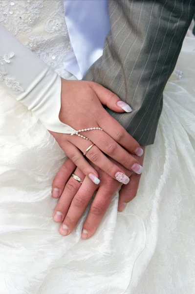 Mani dello sposo e della sposa con fedi nuziali — Foto Stock
