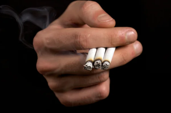 Fumador sosteniendo tres cigarrillos —  Fotos de Stock