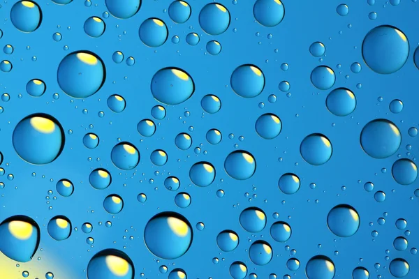 Blue drops with yellow reflection — Stock Photo, Image