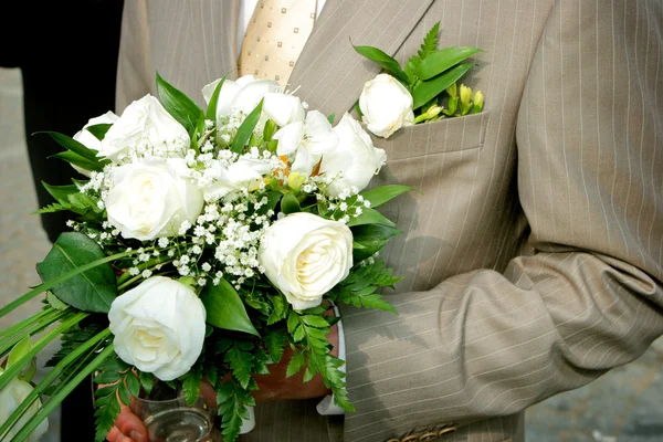 Um noivo segurando um buquê de rosas — Fotografia de Stock