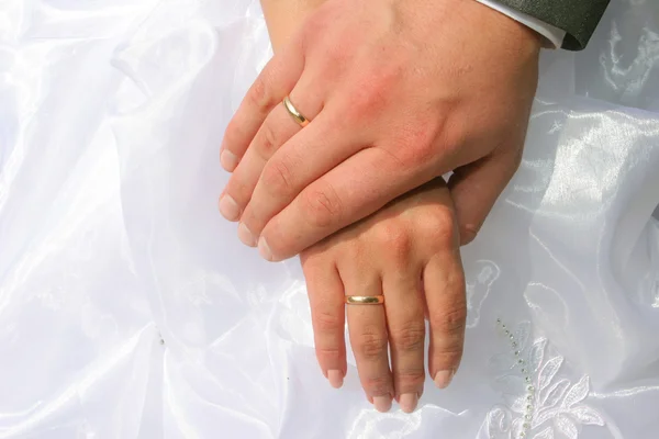 Mãos de recém-casados com alianças de casamento — Fotografia de Stock