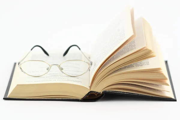 Glasögon på en öppen bok — Stockfoto