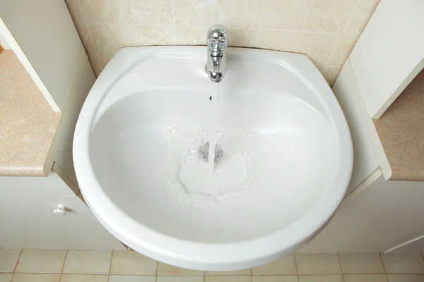 Умывальник с водой в ванной комнате — стоковое фото