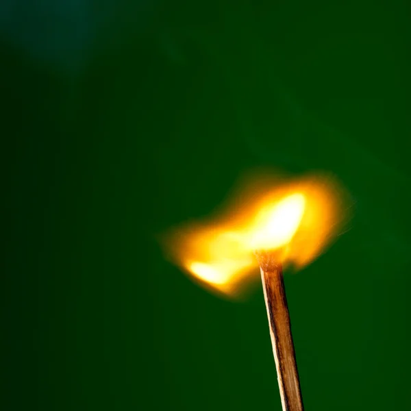 Brinnande tändsticka på gröna — Stockfoto