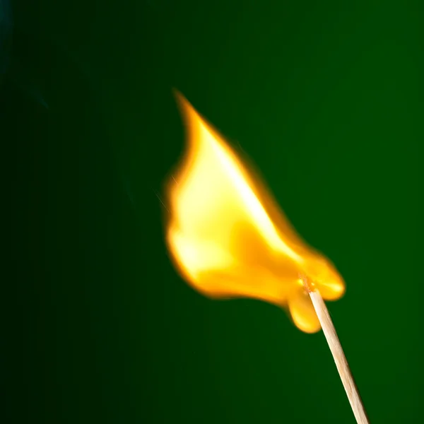 Fósforo ardente com língua de chama no verde — Fotografia de Stock