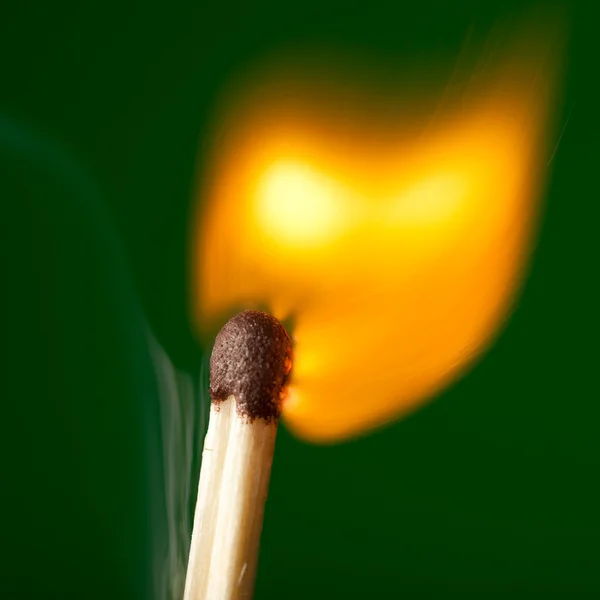 Brinnande tändsticka på gröna — Stockfoto