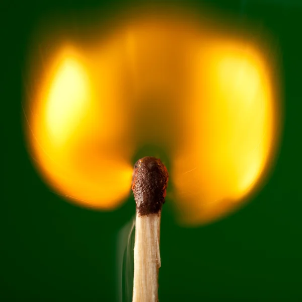 Igniting match on green — Stock Photo, Image
