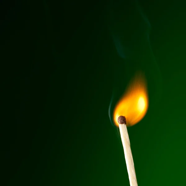 Hořící zápalkou na zelené — Stock fotografie