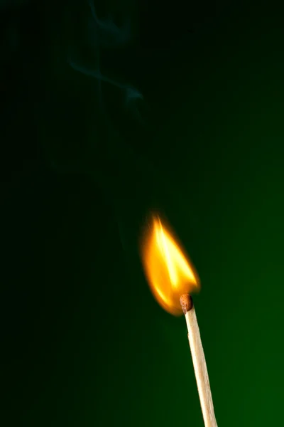 Brennendes Streichholz auf Grün — Stockfoto