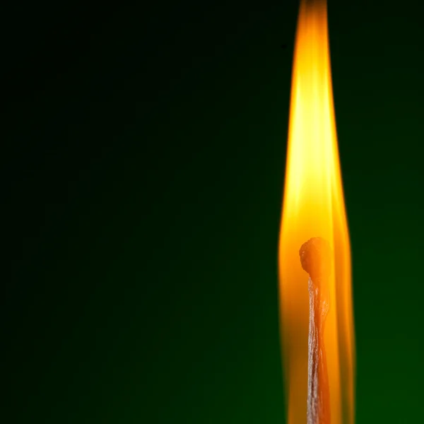 Brandende lucifer op groen — Stockfoto