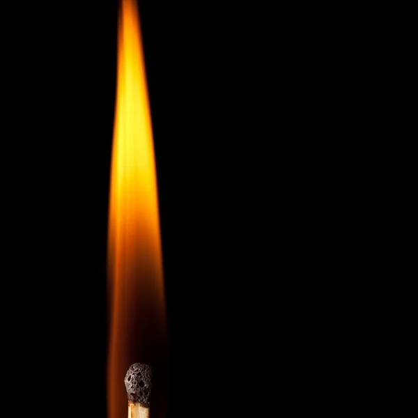Igniting match with tongue of flame on black — Stock Photo, Image
