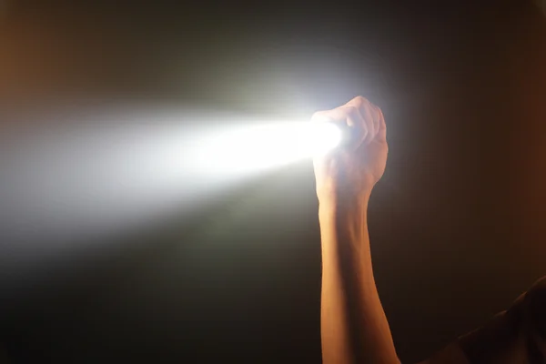 Mão segurando lanterna bolso — Fotografia de Stock