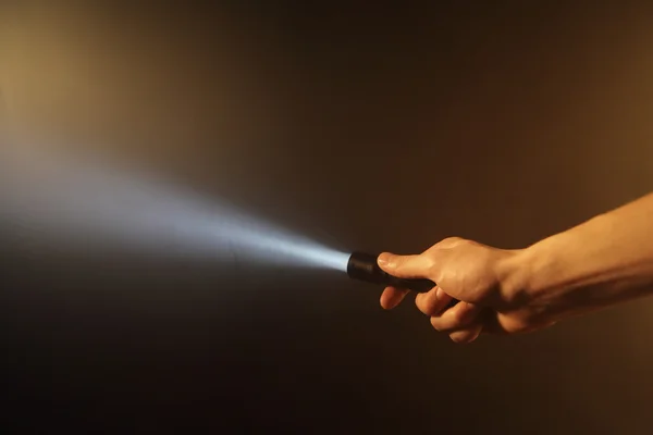 Mão segurando lanterna bolso — Fotografia de Stock