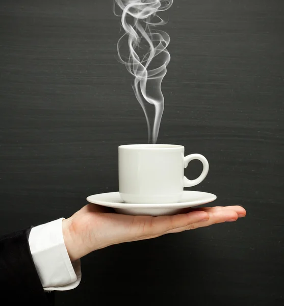 Mão segurando uma xícara com café quente — Fotografia de Stock