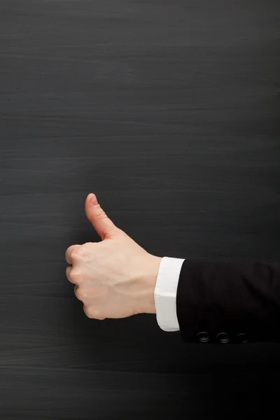 Thumbs up against blackboard background — Stock Photo, Image