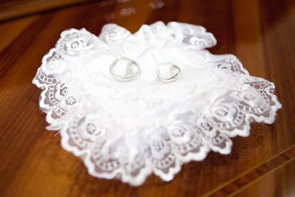 Anéis de casamento em um travesseiro acetinado — Fotografia de Stock